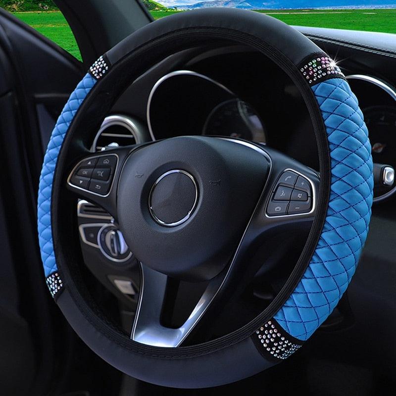 Blue steering wheel cover with decorative elements on a car steering wheel.