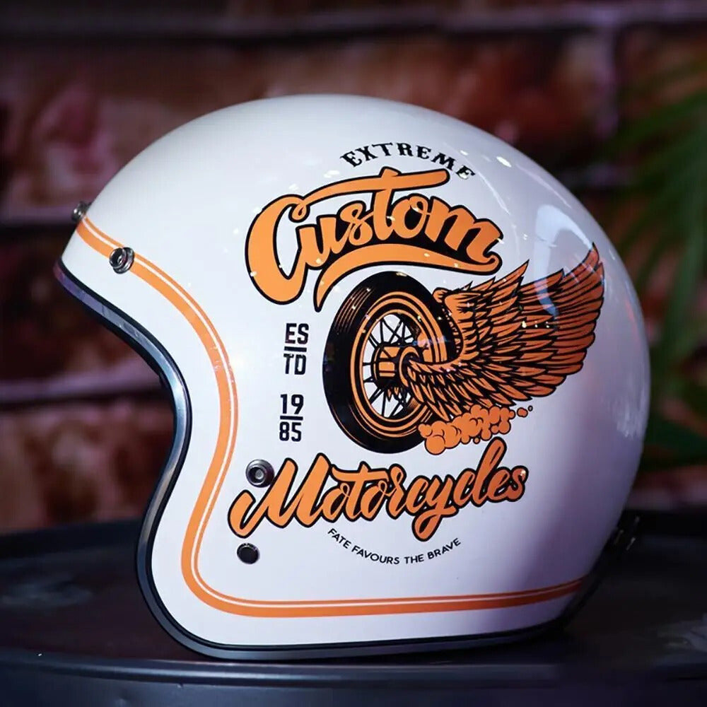White motorcycle helmet with orange and black graphics and text on a blurred background