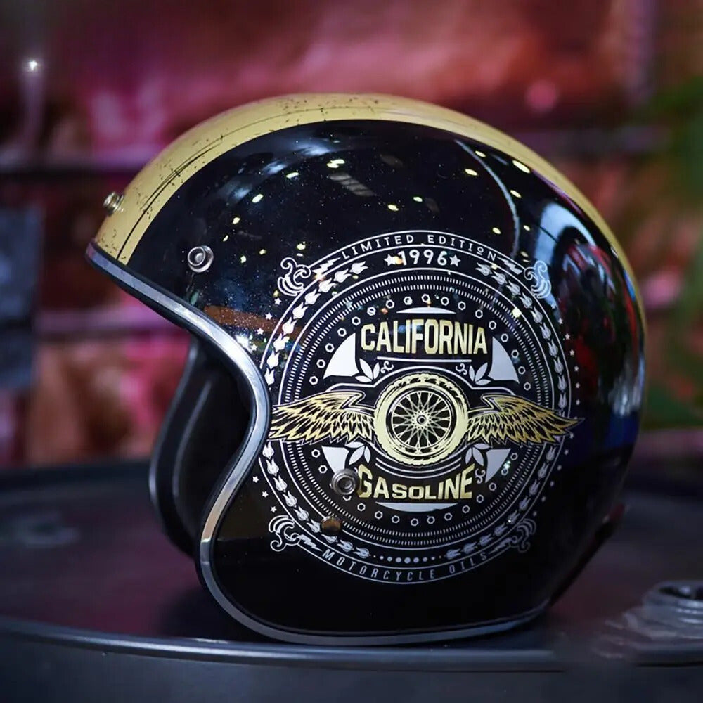 Black motorcycle helmet with gold and white designs on a blurred background